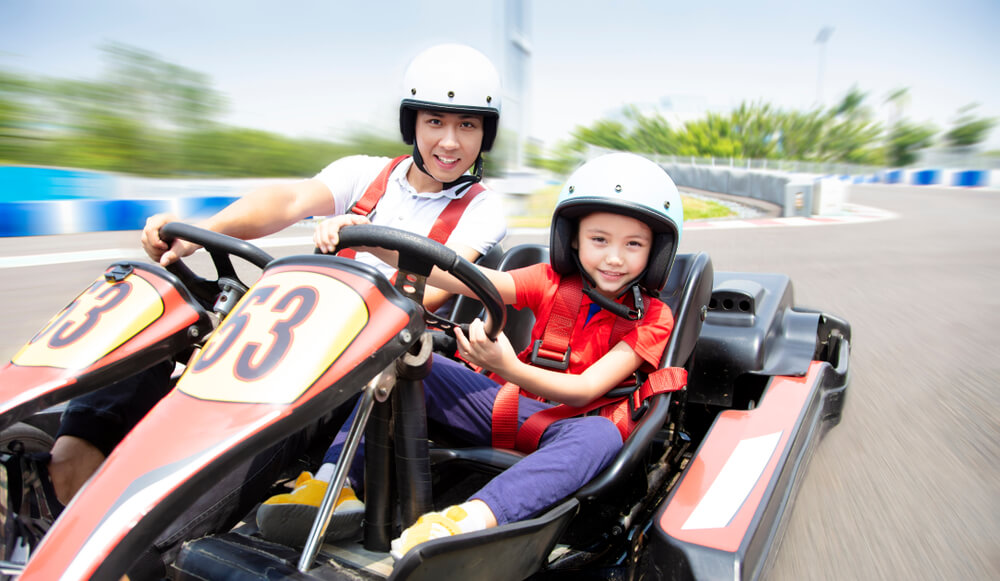 A father and their child racing go karts in Panama City Beach.